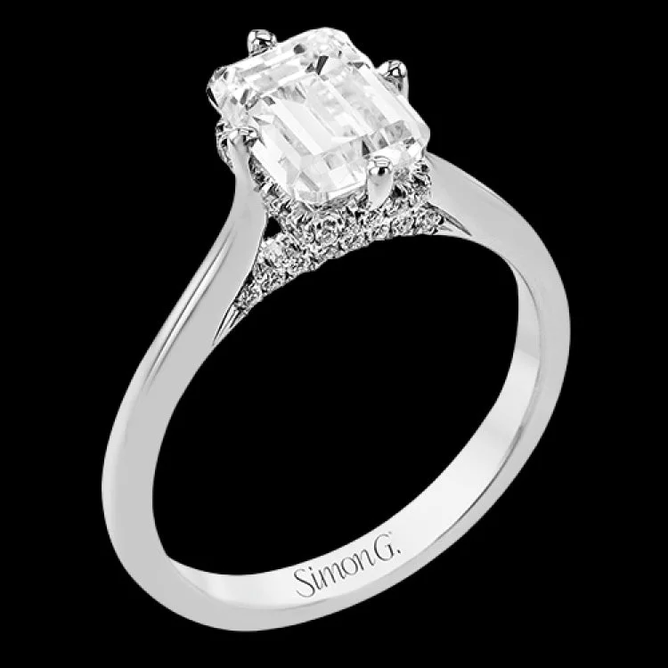 Women’s platinum engagement ring-This elegant white gold engagement ring takes an Emerald center and is adorned with a delicate under halo, and a line of diamonds on the side profile 0.13 ctw